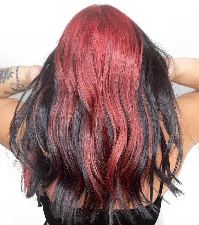Vivid red peekaboo highlights under black hair